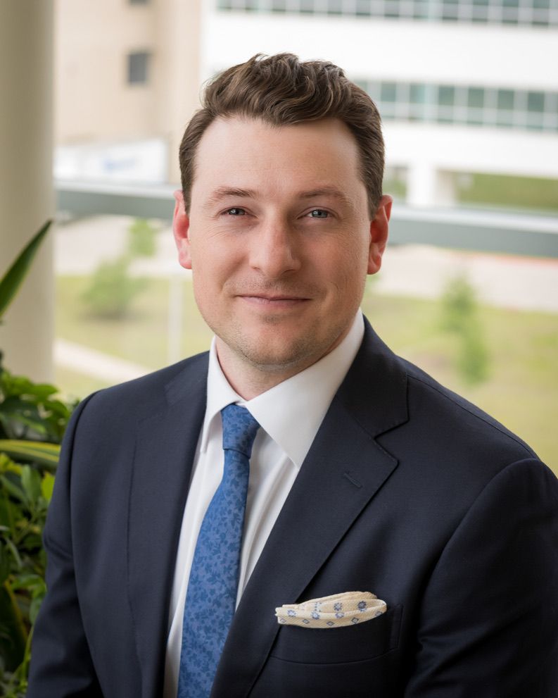 Businessman smiling against wooden backdrop.