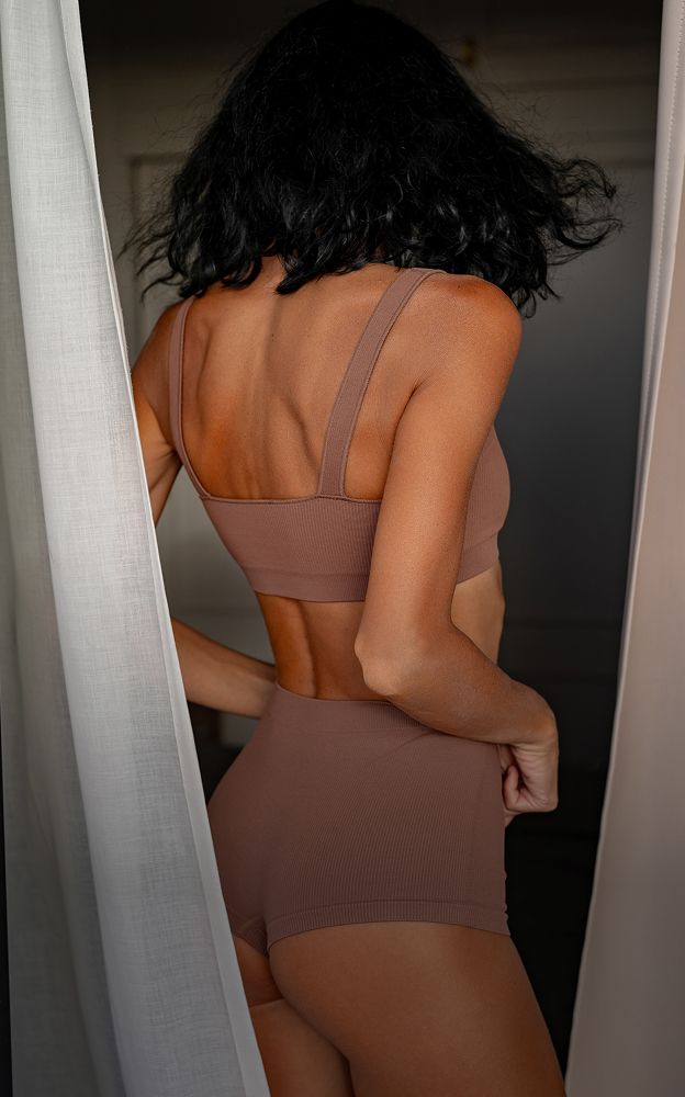 Woman in brown activewear, back view.