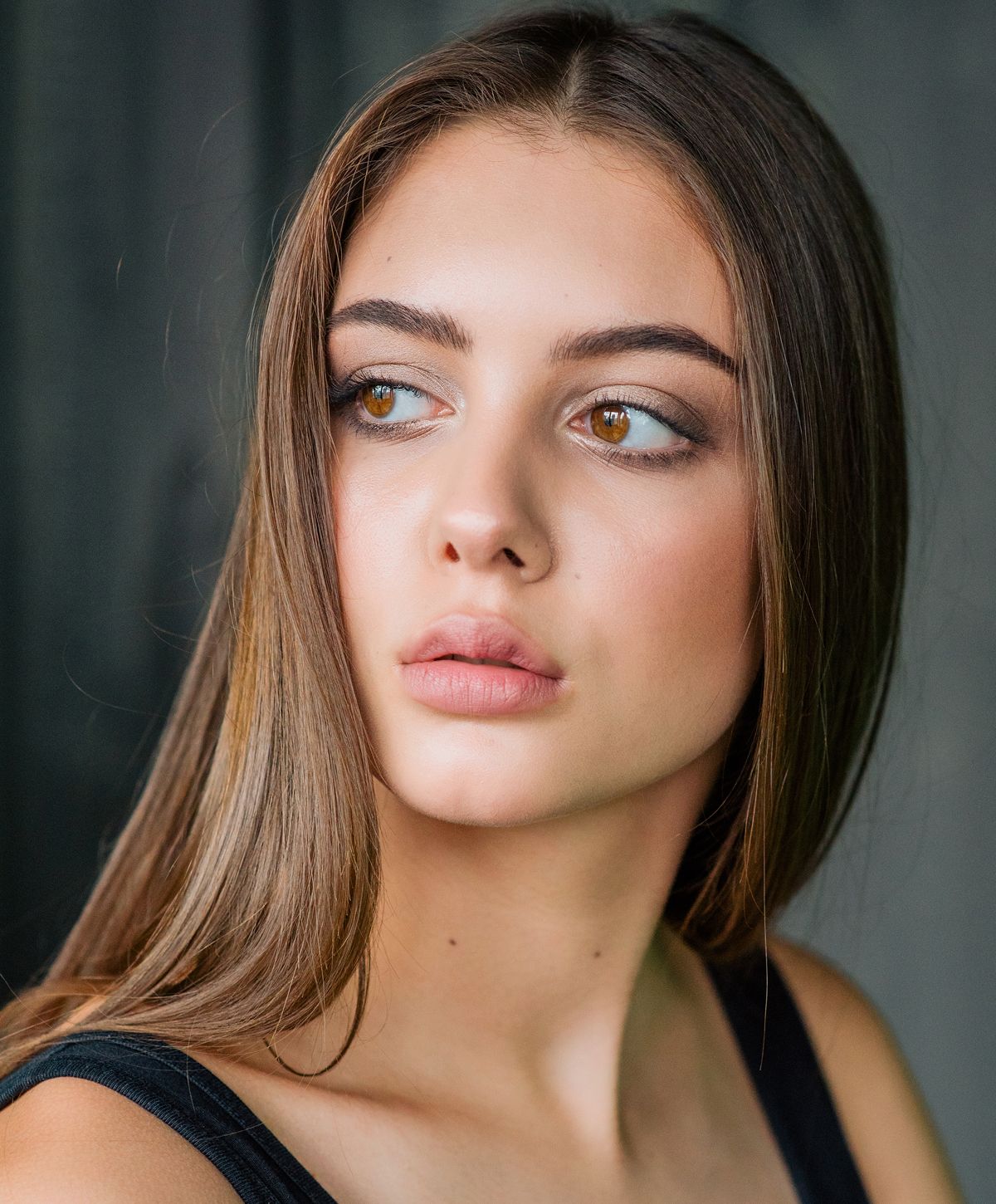 Young woman with long hair, soft makeup.