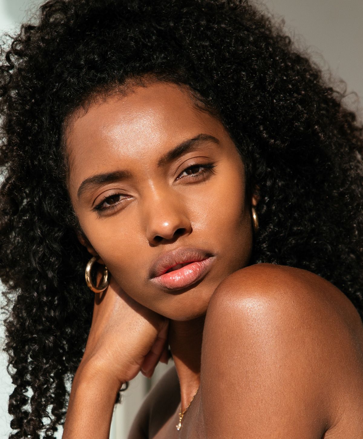 Close-up of woman with curly hair and soft skin.