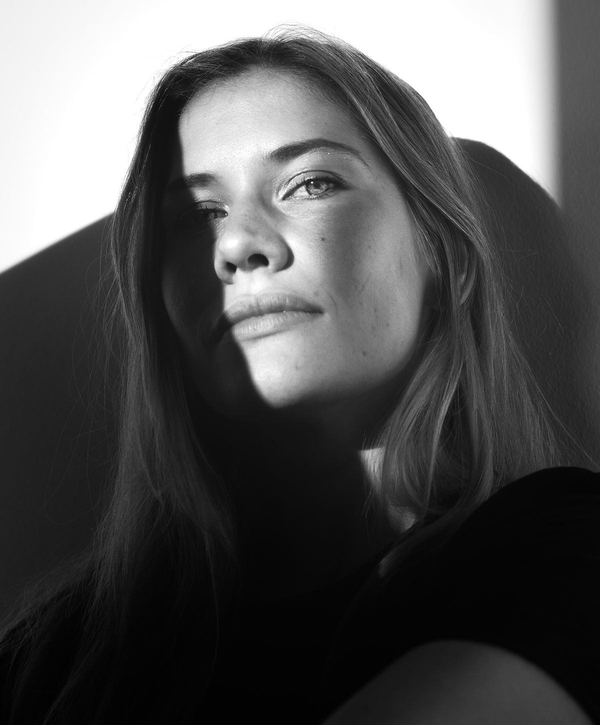 Woman's face partially illuminated in black and white.