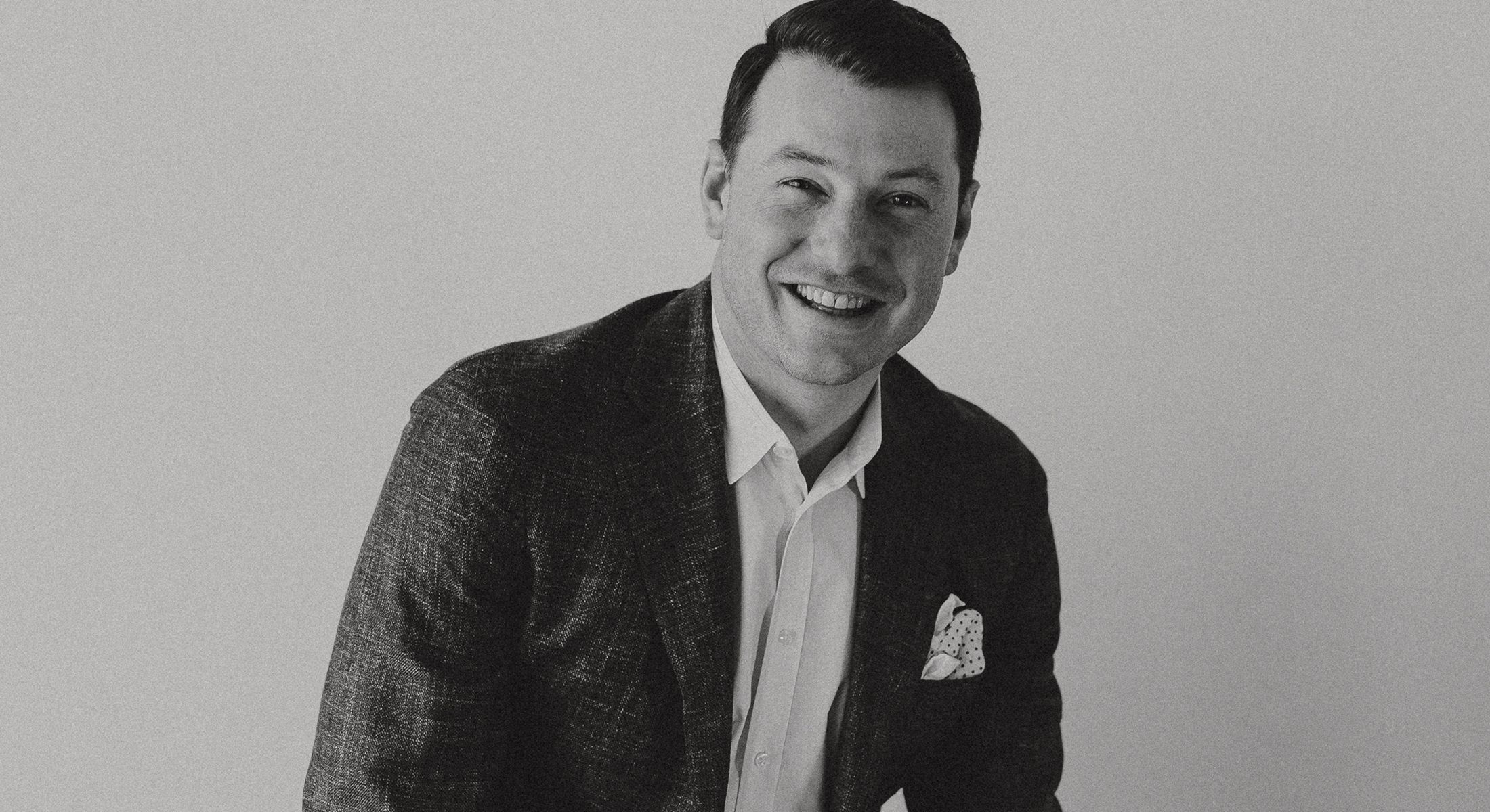 Smiling man in a suit with a pocket square.