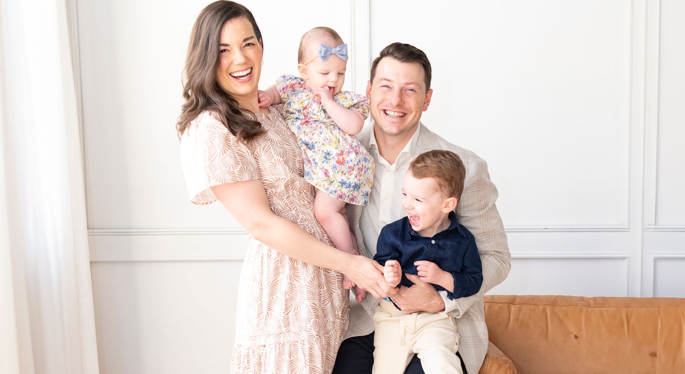 Happy family posing together in a bright room.