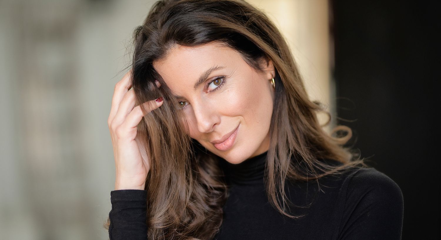 Woman with long hair smiling and posing.